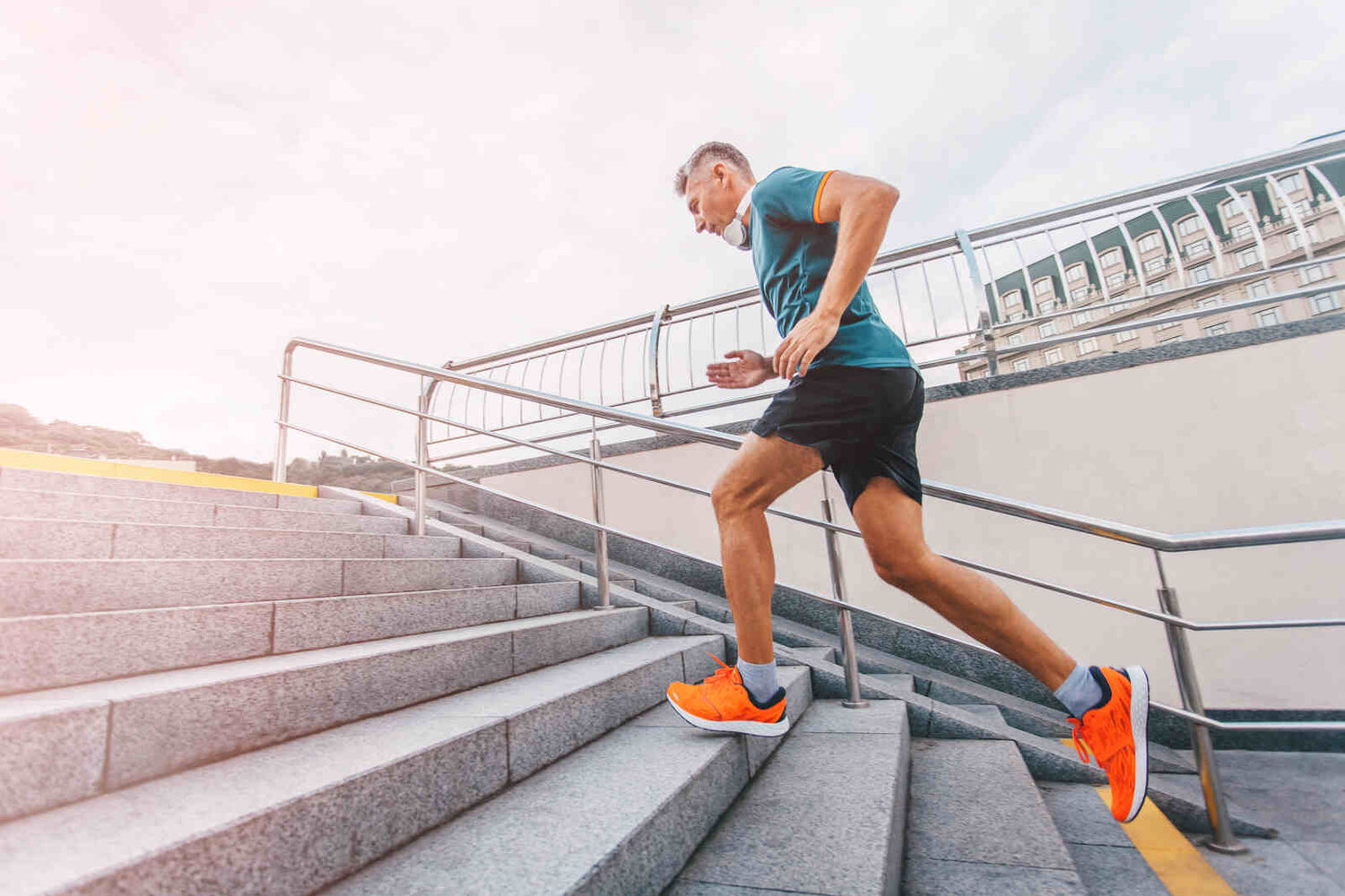 middle aged man runner running upstairs on city stairs